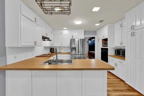 a kitchen with kitchen island a counter top space a sink stainless steel appliances and cabinets