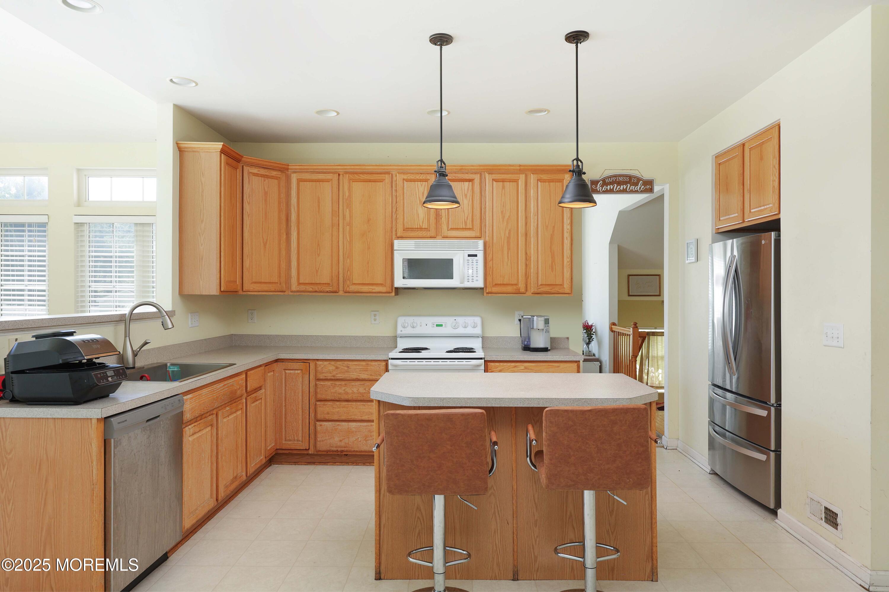 32 Firestone Drive Howell, NJ 07731 - Photo 12 of 43 a kitchen with stainless steel appliances a sink a stove a refrigerator a center island and cabinets