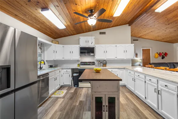 a kitchen with stainless steel appliances granite countertop a sink window and cabinets