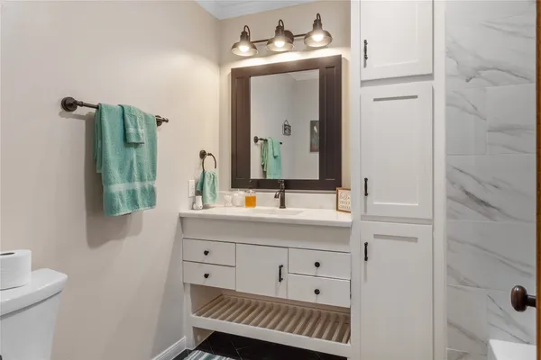a bathroom with a sink a toilet and mirror