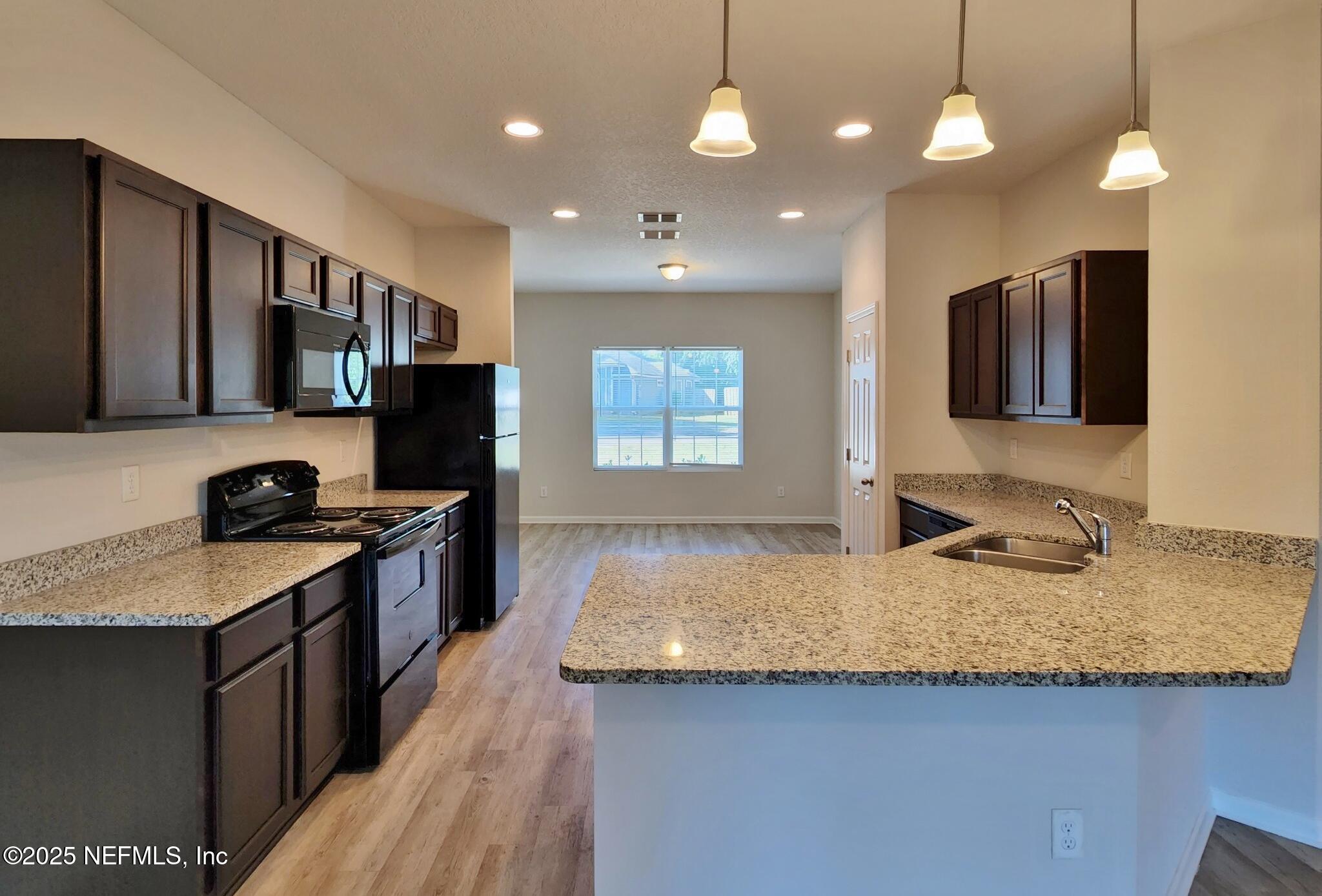 839 Pine Moss Road Jacksonville, FL 32218 - Photo 2 of 5 a kitchen with kitchen island granite countertop stainless steel appliances a sink stove and refrigerator
