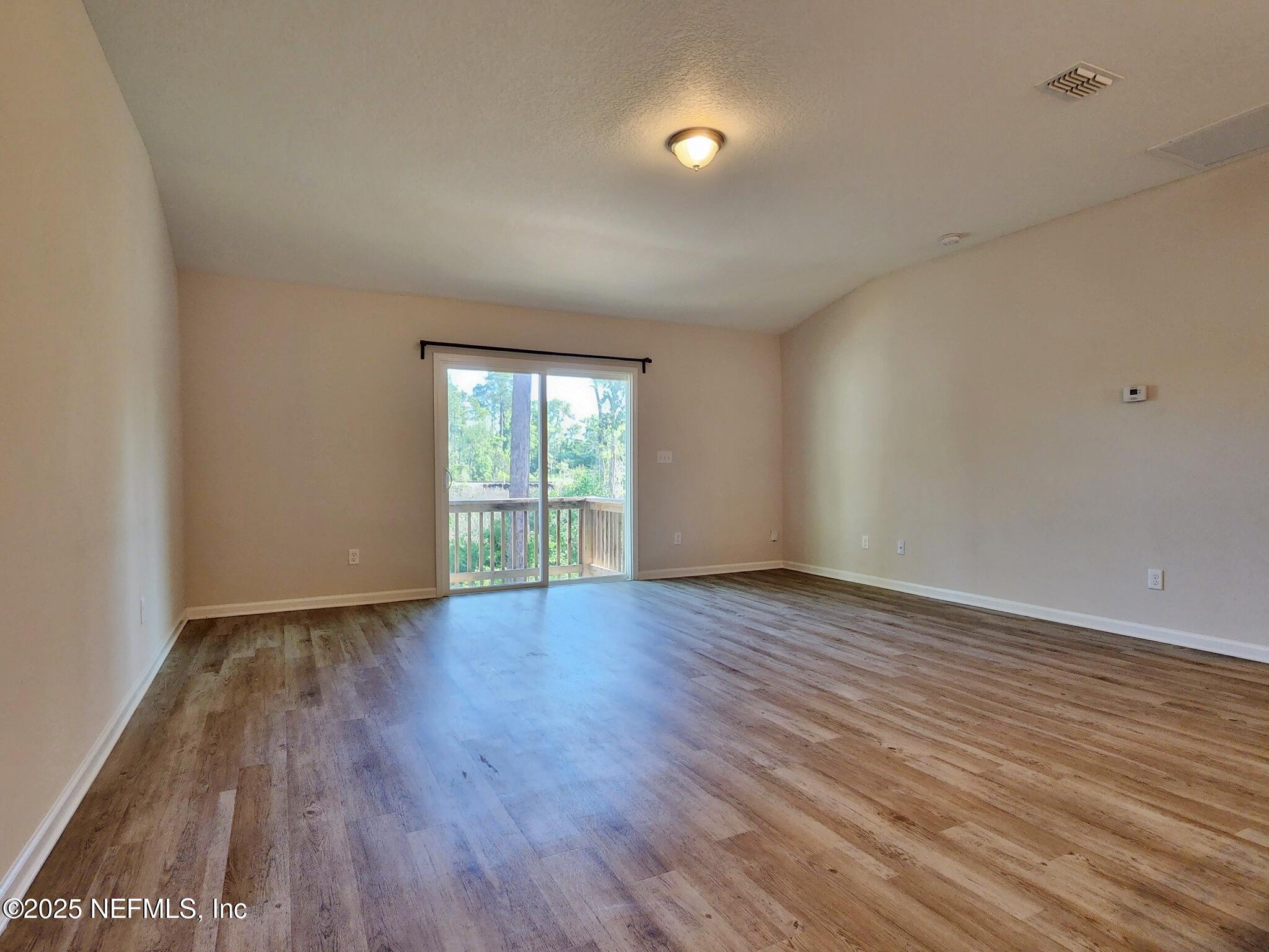 839 Pine Moss Road Jacksonville, FL 32218 - Photo 4 of 5 a view of an empty room with wooden floor and a window