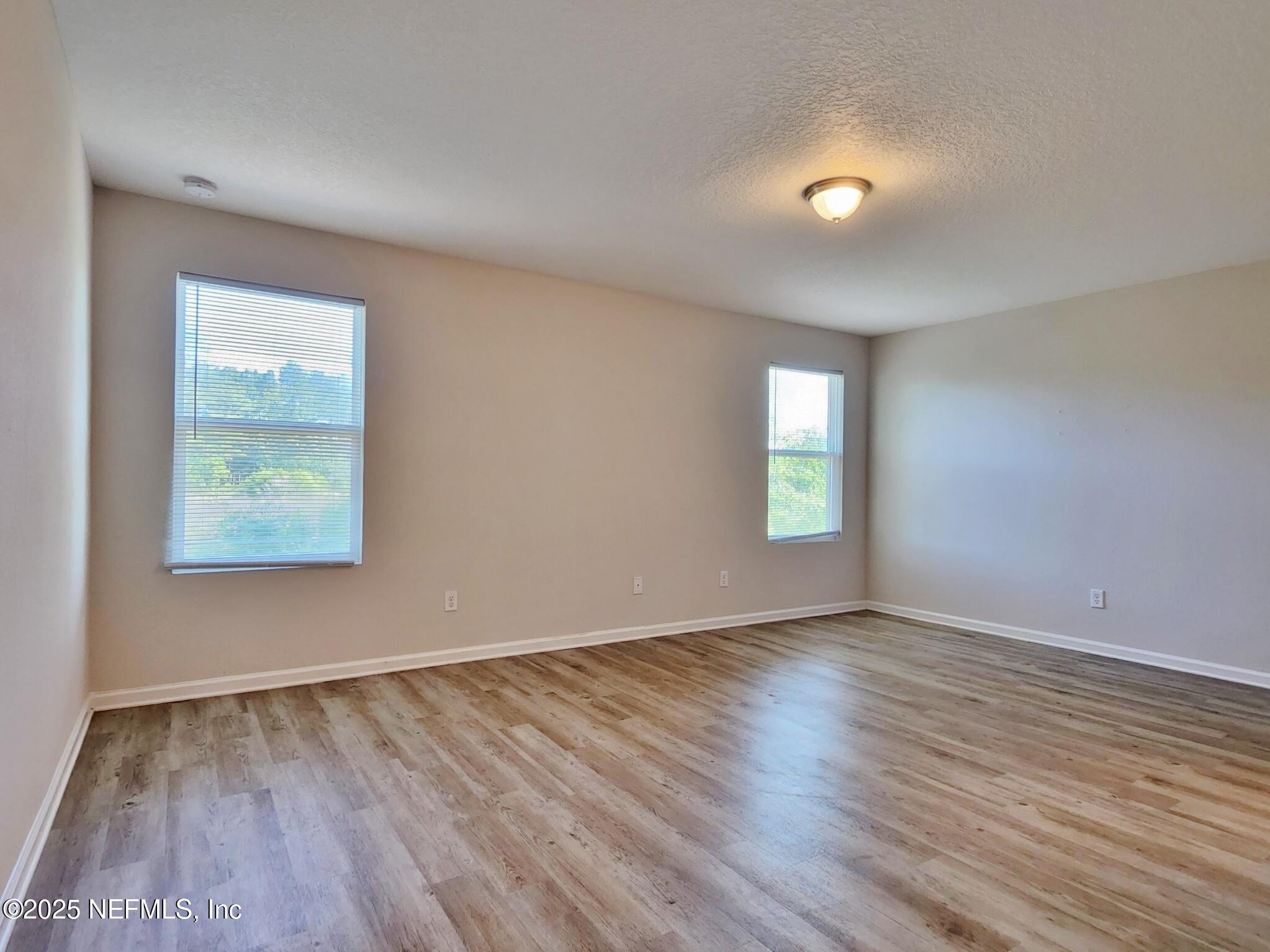 839 Pine Moss Road Jacksonville, FL 32218 - Photo 5 of 5 an empty room with wooden floor and windows