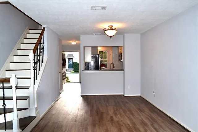 an entryway and a kitchen with wooden floor