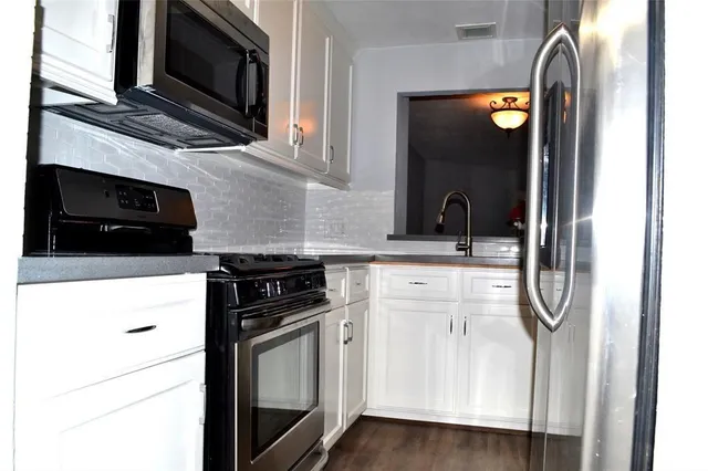 a kitchen with stainless steel appliances white cabinets and a stove