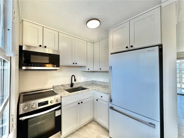 a kitchen with stainless steel appliances white cabinets and a stove top oven