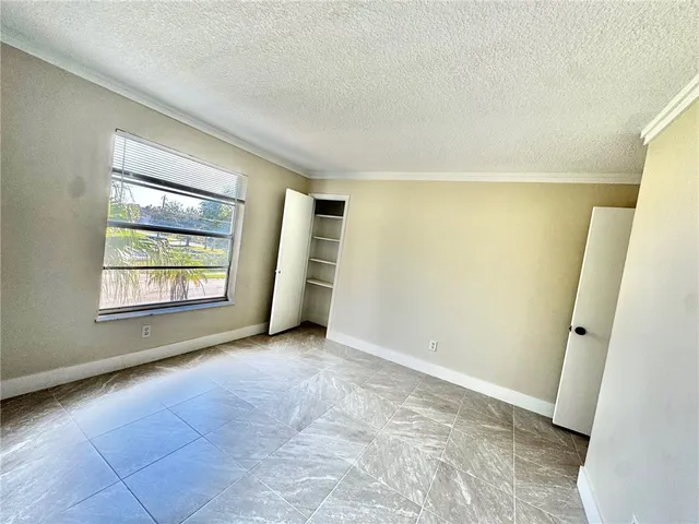 an empty room with windows and closet