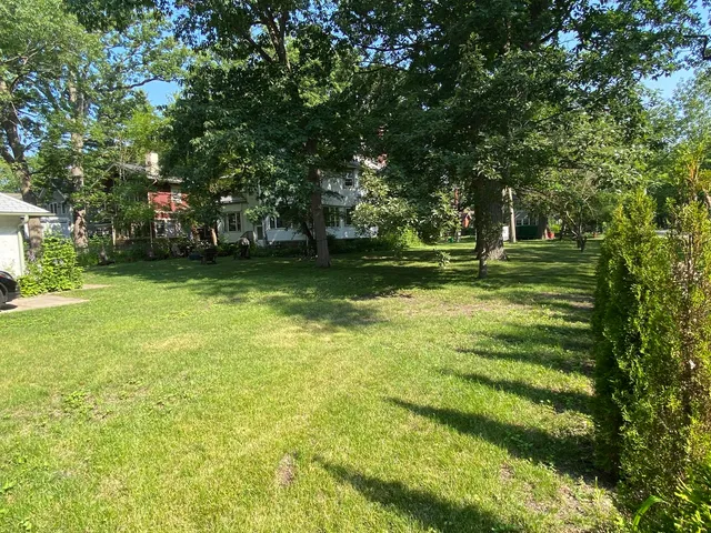 a backyard of a house with lots of green space and fountain