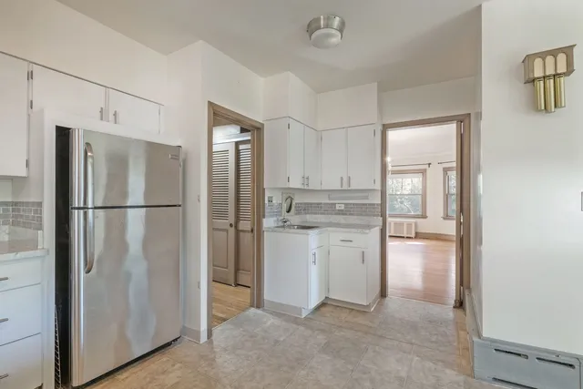a kitchen with a refrigerator a sink and cabinets