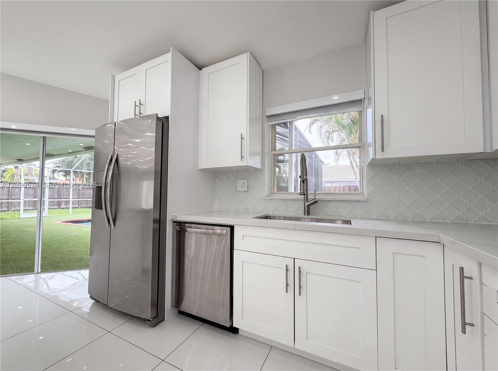 16571 Southwest 145th Avenue Miami, FL 33177 - Photo 2 of 25 a kitchen with a refrigerator sink and cabinets