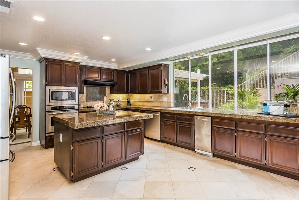 4224 San Ramon Drive Corona, CA 92882 - Photo 22 of 43 Chefs Kitchen complete with Granite counters and center island. Walk in Pantry and Stainless Appliances including built-in microwave and trash compactor. 5 Burner Gas Range.