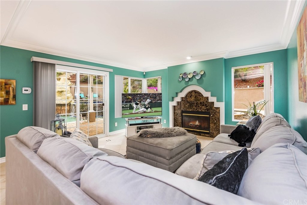 4224 San Ramon Drive Corona, CA 92882 - Photo 27 of 43 Family Room offers full wet bar with built-in wine cooler. Slider window door creates easy access and open views to the beautiful backyard. Marble accented fireplace.