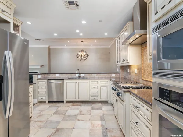 a kitchen with stainless steel appliances granite countertop a refrigerator and a stove top oven