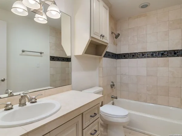 a bathroom with a sink a toilet a mirror and shower