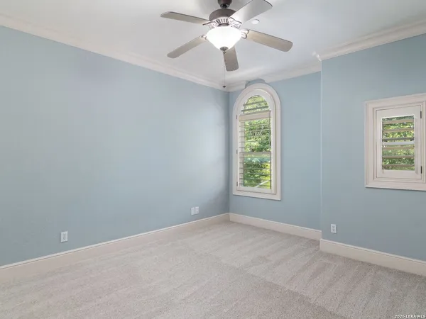 an empty room with a window and a fan