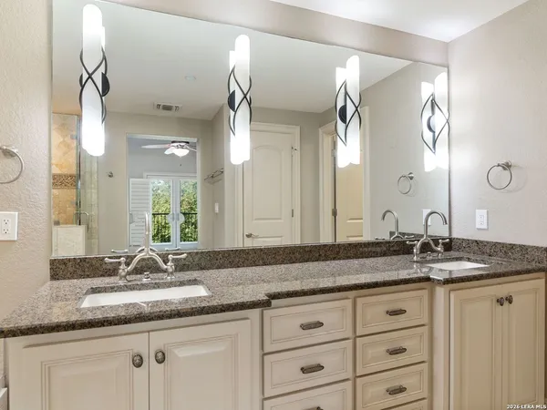 a bathroom with a granite countertop sink double and mirror