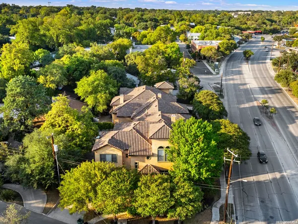 an aerial view of residential houses with outdoor space and trees all around