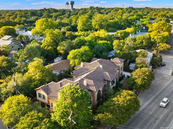 an aerial view of a house with a yard and trees all around