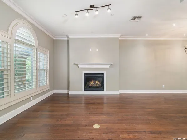 a view of an empty room with glass door and wooden floor