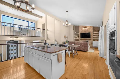 a kitchen with stainless steel appliances granite countertop a stove and a wooden floors