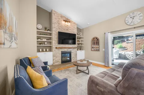 a living room with furniture a flat screen tv and a fireplace