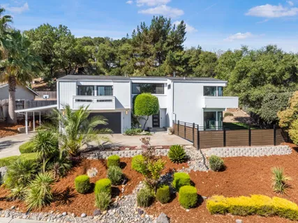 a view of a house with chairs and flower plants
