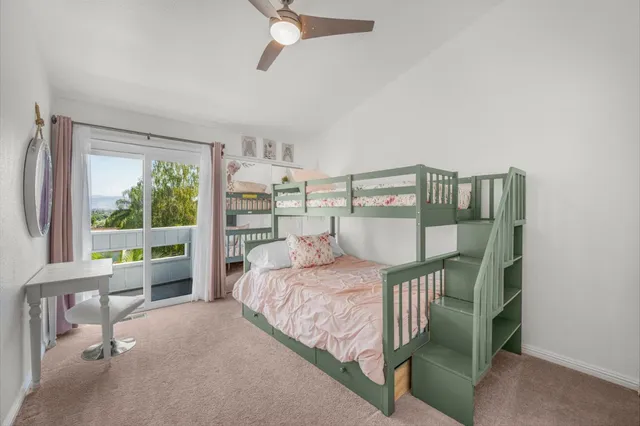 a bedroom with a bed a large window and book shelf