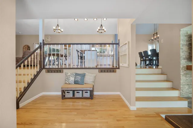 a view of staircase with lots of frames on wall and wooden floor