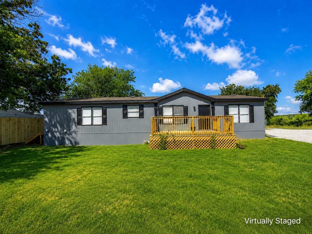 18327 Gholson Road Waco, TX 76705 - Photo 1 of 19 Single-story exterior with gray siding, black window shutters, and a wood-finish deck with latticework