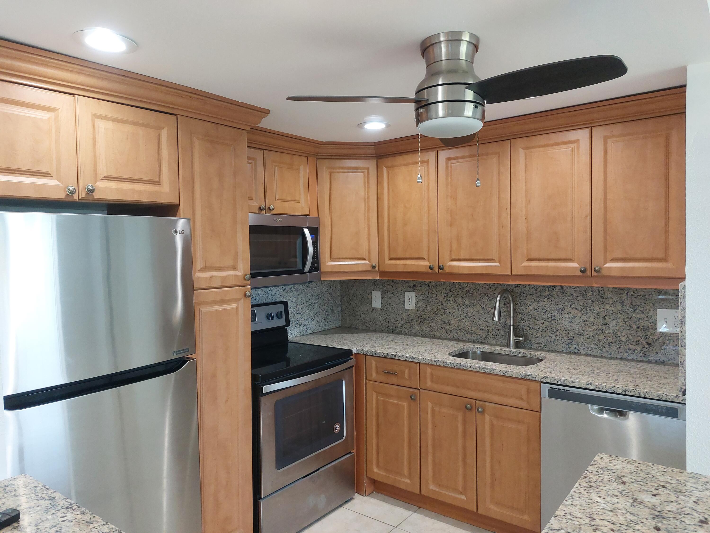 362 Tuscany G Delray Beach, FL 33446 - Photo 2 of 10 a kitchen with stainless steel appliances granite countertop a refrigerator a sink dishwasher a stove top oven a refrigerator and cabinets