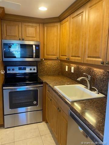 362 Tuscany G Delray Beach, FL 33446 - Photo 3 of 10 a kitchen with a sink stove and microwave