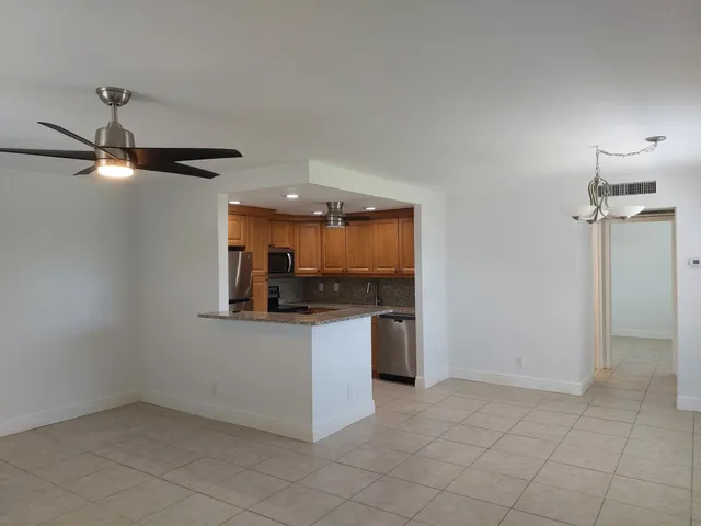 a kitchen with granite countertop a refrigerator and a stove top oven