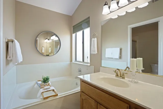 a en suite bathroom with a granite countertop sink and a mirror