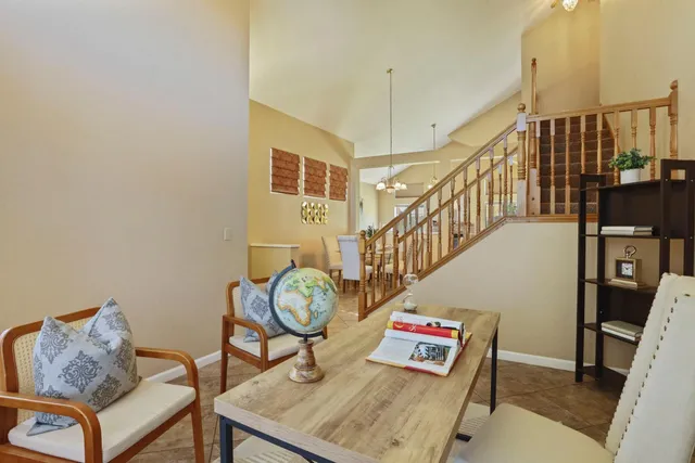 a living room with couches a rug and a wall painting