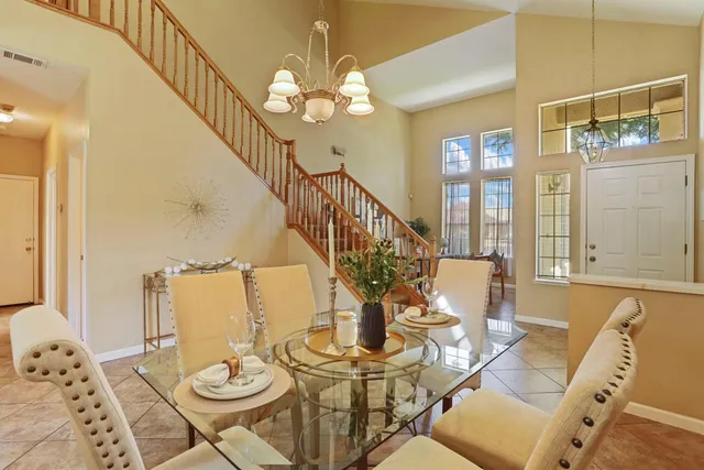 a view of a dining room with furniture a chandelier and wooden floor
