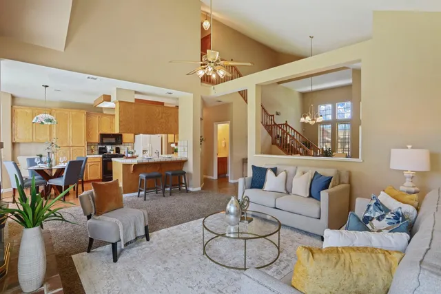 a living room with furniture kitchen view and a large window