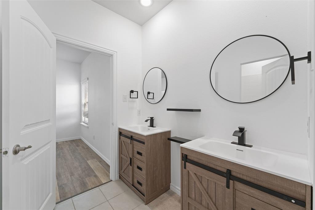 4651 Raleigh Dalton Road Dallas, TX 75227 - Photo 15 of 19 Dual vanity with wood-finish cabinetry and matte black hardware