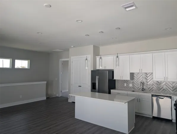a living room with furniture and a refrigerator