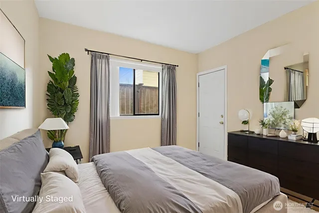 a bedroom with a bed lamp and a potted plant