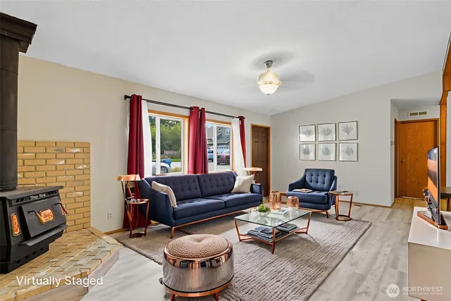 a living room with furniture a flat screen tv and a window