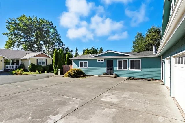 a view of a house with table and chairs under an umbrella
