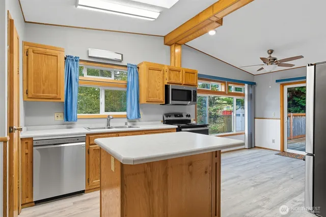 a kitchen with wooden cabinets a sink stove and refrigerator