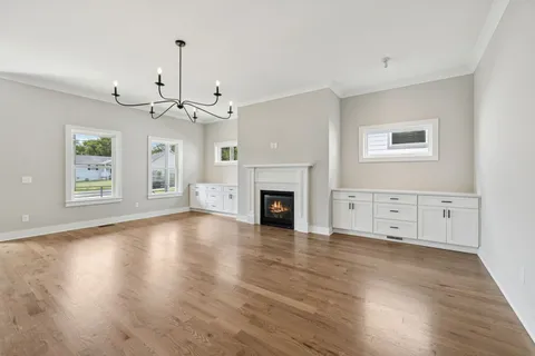 a view of a livingroom with wooden floor fireplace and windows