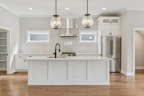 a kitchen with refrigerator cabinets and wooden floor
