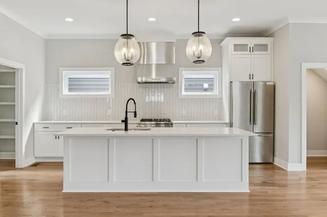 a kitchen with refrigerator cabinets and wooden floor