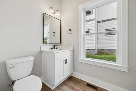 a bathroom with a toilet sink and mirror