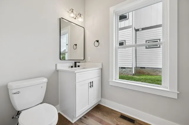 a bathroom with a toilet sink and mirror