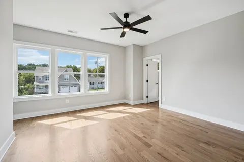 an empty room with wooden floor and windows