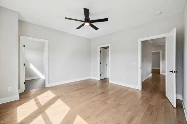 a view of a livingroom with wooden floor and a ceiling fan