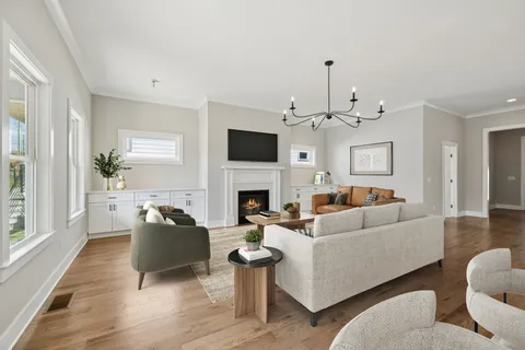a living room with furniture a fireplace and a chandelier